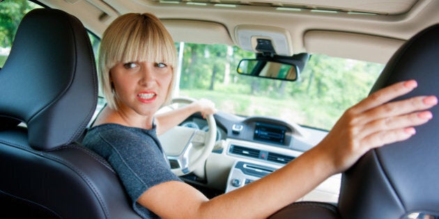 attractive woman driver looking back and parking car