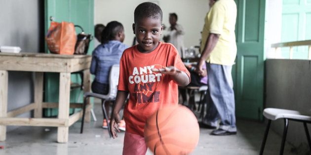 Un jeune garçon joue avec un ballon qu'il vient de recevoir au centre de distribution de l’UNICEF, à Saint John’s, à Antigua.