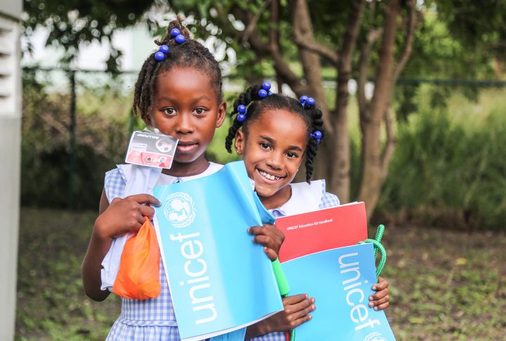 Deux jeunes filles ont reçu du matériel éducatif et récréatif au centre de distribution de l'UNICEF, à Saint John's, à Antigua.