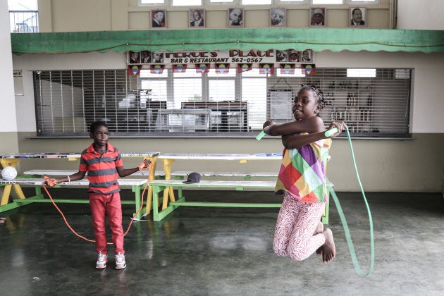 Desre Simon et son frère Unique Simon sautent à la corde, après avoir reçu du matériel récréatif, à Saint John's, à Antigua.