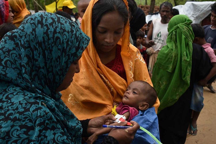 Une nutritionniste mesure la circonférence du bras du jeune Anamul, âgé de neuf mois.