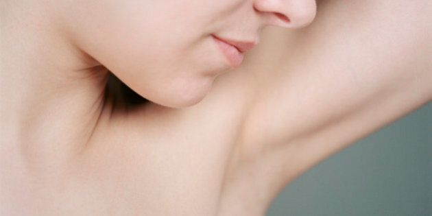 Young woman smelling armpit, close up