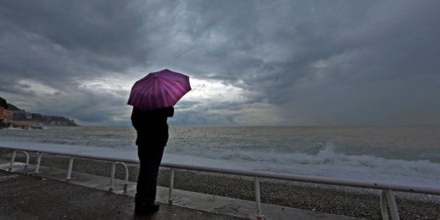 A woman protects herself under an umbrella during an autumn day on the Promenade Des Anglais in Nice while heavy rain and storm hit the French Riviera November 5, 2014. REUTERS/Eric Gaillard (FRANCE - Tags: SOCIETY ENVIRONMENT TPX IMAGES OF THE DAY)