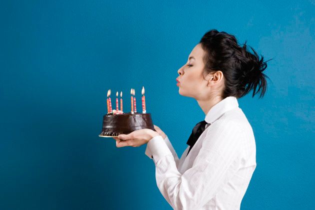 Young woman blowing out birthday candles