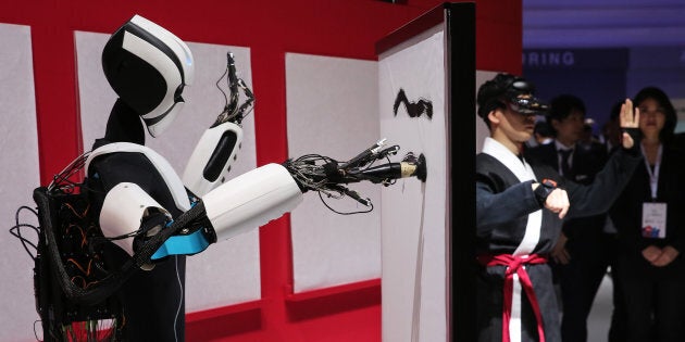 Un robot, contrôlé par un humain, peint.