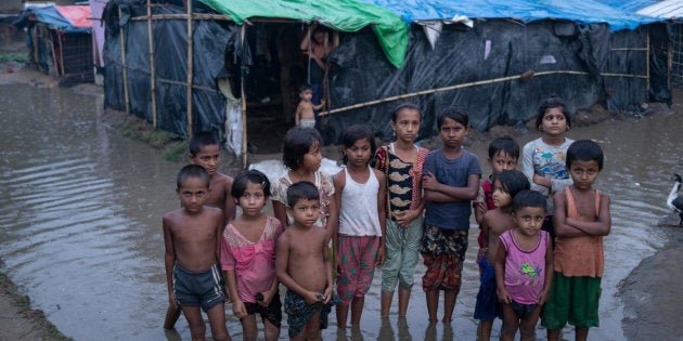 Des enfants rohingyas marchent péniblement dans l'eau, alors que les pluies ont encerclé leurs abris de fortune, suite à des pluies intenses. District de Cox's Bazar, Bangladesh, 20 mai 2018.