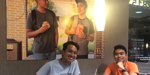 Jevh et son ami Christian, devant le faux poster d'eux-mêmes collé dans un restaurant McDonald's.