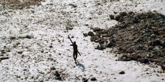 La photo, prise le 28 décembre 2004, montre un homme de la tribu des Sentinelles qui dirige son arc et sa flèche vers un hélicoptère des garde-côtes indiens lors d'un survol de l'île North Sentinel, dans les îles Andaman, en Inde.