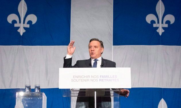 Le premier ministre du Québec devant un très grand drapeau lors de la mise à jour économique de la province, le 3 décembre 2018.