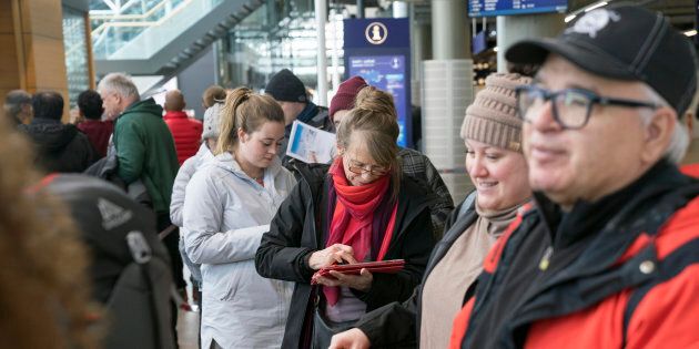 De nombreux passagers qui devaient voyager avec Wow Air attendent en ligne à l'aéroport de Keflavik, en Islande, jeudi, pour se trouver un autre vol.