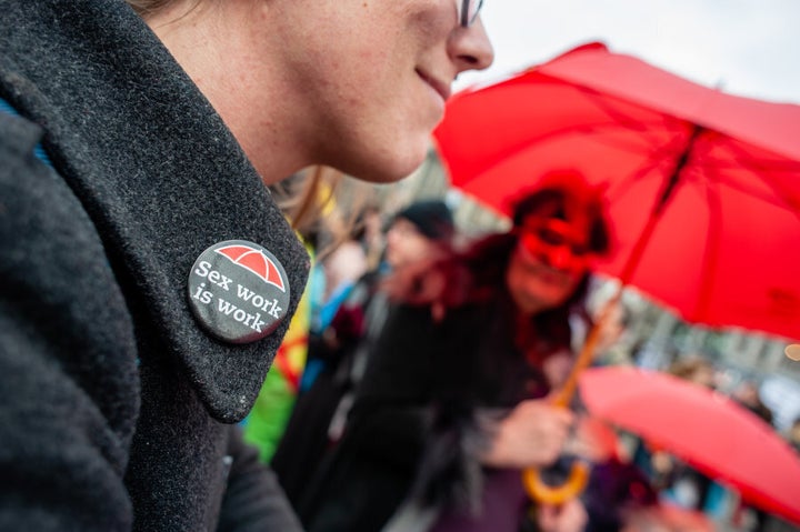 Une participante à la marche internationale de la journée des femmes porte un macaron indiquant que le travail du sexe est un travail.