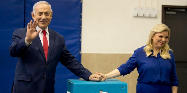 Le premier ministre israélien Benjamin Netanyahu, à gauche, fait des vagues avec sa femme Sara après avoir voté lors des élections législatives israéliennes à Jérusalem, le mardi 9 avril 2019.