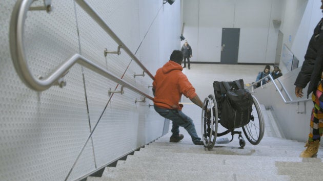 Woddy Belfort descend les marches avec son fauteuil roulant à la station Berri-UQÀM.