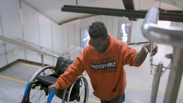 Woody Belfort escalade les marches avec son fauteuil roulant à la station Berri-UQÀM.