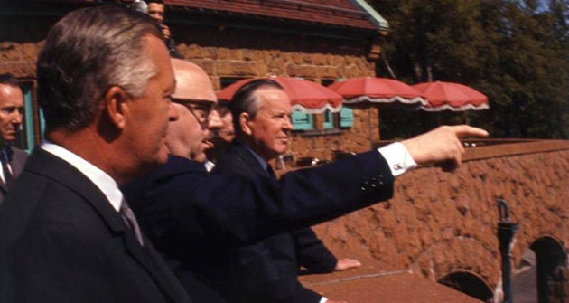 Le maire de Montréal, Jean Drapeau, pointe vers les travaux de construction d'Expo 67. Avec lui, les premiers ministres du Québec Jean Lesage (gauche) et du Canada Lester B. Pearson.