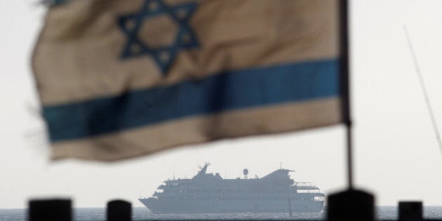 An Israeli flag flutters in the wind as a naval vessel (not seen) escorts the Mavi Marmara, a Gaza-bound ship that was raided by Israeli marines, to the Ashdod port May 31, 2010. REUTERS/Amir Cohen/File Photo