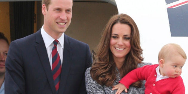 Britain's Prince William, left, and Kate, the Duchess of Cambridge, center, along with son Prince George, stand atop of the stairs to say good bye as they board their flight in Canberra, Australia, Friday, April 25, 2014. The Duke and Duchess concluded their three week state visit by attending the Anzac Day dawn service and parade, laying a wreath and planting a Lone Pine tree before departing for London with son Prince George.(AP Photo/Rob Griffith)