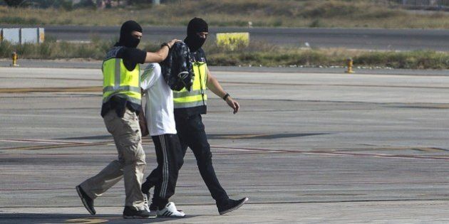 Spanish police escort a man on the tarmac of an airport of the Spanish enclave of Melilla on July 22, 2015. Police in Spain's north African territory Melilla arrested a man suspected of recruiting women for the armed jihadist group Islamic State, the government said today. Spanish police working with Moroccan security services seized the man overnight in an investigation into gangs suspected of recruiting women and minors to send them to Syria and Iraq. AFP PHOTO/ ANGELA RIOS (Photo credit should read ANGELA RIOS/AFP/Getty Images)