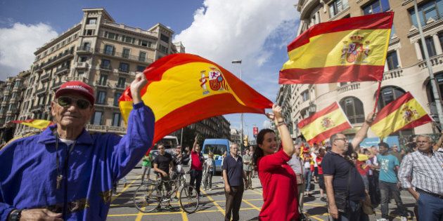 BARCELONA, SPAIN - OCTOBER 12: Anti-independence Catalan protestors carry Spanish flags during a demonstration for the unity of Spain on the occasion of the Spanish National Day at Catalunya square in Barcelona on October 12, 2014. (Photo by Albert Llop/Anadolu Agency/Getty Images)