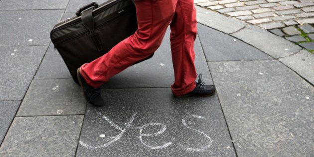 A person walks by a message left by a member of the Yes campaign written on a pavement, in Edinburgh, Scotland, Wednesday, Sept. 17, 2014. The two sides in Scotland's independence debate are scrambling to convert undecided voters, with just one day to go until a referendum on separation. (AP Photo/Scott Heppell)