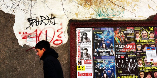SIMFEROPOL, UKRAINE - MARCH 13: Advertisments are viewed along a wall on a street on March 13, 2014 in the Crimean city of Simferopol, Ukraine. As the standoff between the Russian military and Ukrainian forces continues in Ukraine's Crimean peninsula, world leaders are pushing for a diplomatic solution to the escalating situation. Crimean citizens will vote in a referendum on 16 March on whether to become part of the Russian federation. (Photo by Spencer Platt/Getty Images)
