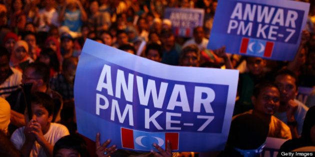Supporters of the People's Justice Party hold placards reading 'Anwar the 7th prime minister' during their party's campaign event on the eve of country's 13th general elections in Lembah Pantai on May 4, 2013. Anwar Ibrahim said only fraud can stop his Malaysian opposition from scoring a historic election win as the rival sides launched a last-ditch campaign blitz Saturday on the eve of a tense vote. AFP PHOTO / MOHD RASFAN (Photo credit should read MOHD RASFAN/AFP/Getty Images)