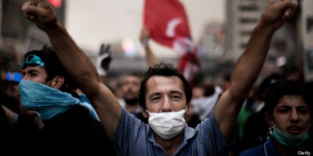 A man flashes a victory sign as people demonstrate in Istanbul on June 4, 2013, during ongoing protests against the ruling party, police brutality, and the destruction of Taksim park for the sake of a development project. Turkey's Islamic-rooted government apologised today to wounded protestors and said it had 'learnt its lesson' after days of mass street demonstrations that have posed the biggest challenge to Prime Minister Recep Tayyip Erdogan's decade in office. Turkish police had on June 1 begun pulling out of Istanbul's iconic Taksim Square, after a second day of violent clashes between protesters and police over a controversial development project. What started as an outcry against a local development project has snowballed into widespread anger against what critics say is the government's increasingly conservative and authoritarian agenda. AFP PHOTO / MARCO LONGARI (Photo credit should read MARCO LONGARI/AFP/Getty Images)