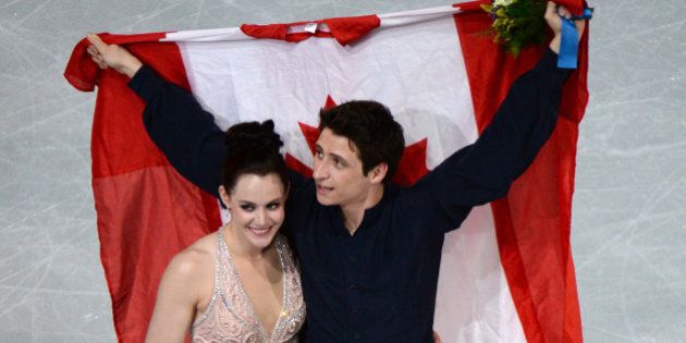 Canada's silver medalists Tessa Virtue and Scott Moir celebrate during the Figure Skating Ice Dance Flower Ceremony at the Iceberg Skating Palace during the Sochi Winter Olympics on February 17, 2014. AFP PHOTO / YURI KADOBNOV (Photo credit should read YURI KADOBNOV/AFP/Getty Images)