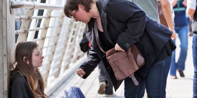 LONDON-APRIL 25: A unidentified woman gives money to a young homeless woman on Charing Cross Bridge on April 25, 2010 in London, UK. Homelessness in England had risen by 42% in 2010 to 1,768, from 1,247 in 2009.