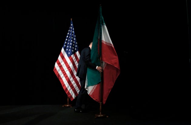 이란 핵협정(JCPoA·포괄적 공동행동계획)에 참여한 유엔 안전보장이사회 상임이사국 5개국(미국, 영국, 프랑스, 러시아, 중국)+독일(5+1)과 이란의 외교 대표자들이 협정 타결 기념촬영을 마친 뒤 한 관계자가 깃발을 옮기는 모습. 오스트리아, 빈. 2015년 7월14일.