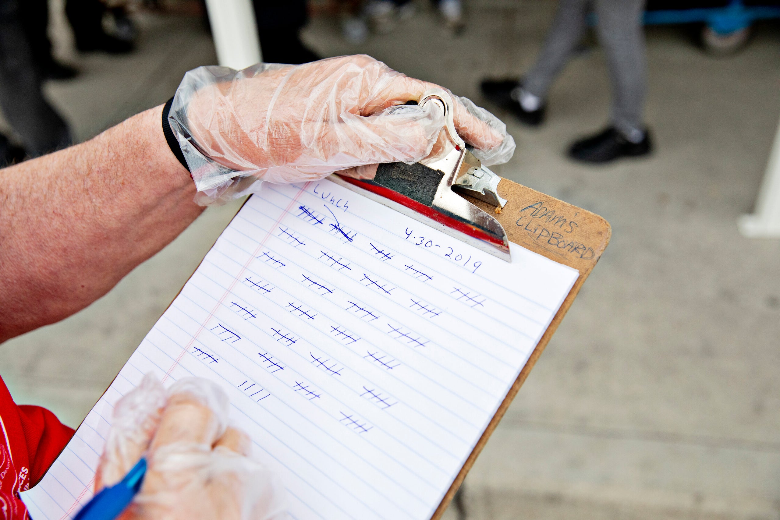 A volunteer counts people receiving lunches at the St. Vincent de Paul Dining Hall.