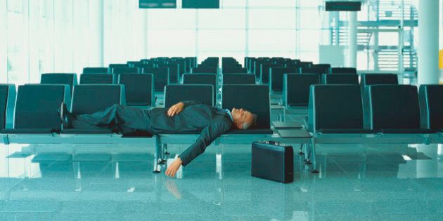 Businessman sleeping in airport lounge