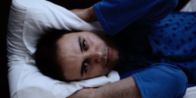 Portrait of a man trying to sleep in his bed