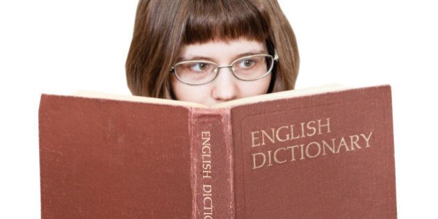 girl with glasses reads big English Dictionary book isolated on white background