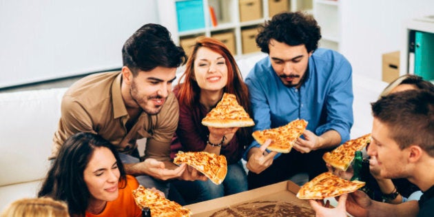 Group of friends eating pizza together.