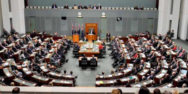 New Zealand's Prime Minister John Key, standing before flags, addresses a joint sitting of the Australian parliament in the House of Representatives chamber at Parliament House in Canberra, Australia, Monday, June 20, 2011. (AP Photo/Alan Porritt, Pool)