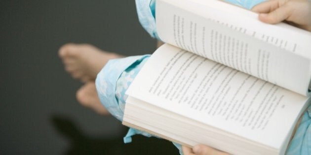 Child reading book, high angle view