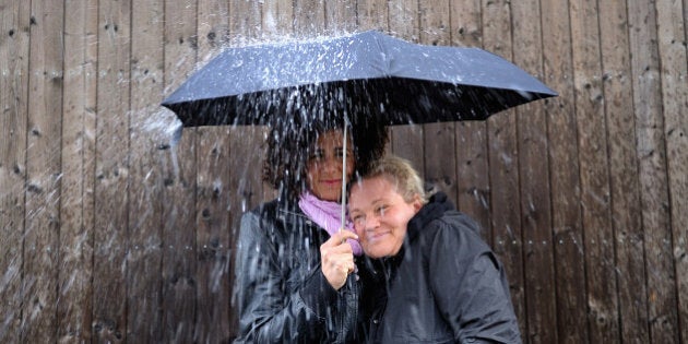 Two women under one umbrella