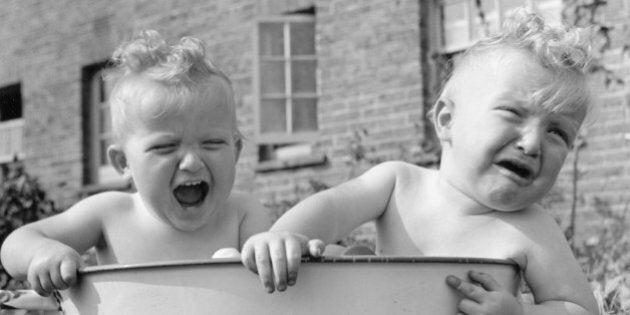 Young twins Martin and Peter Thompson, who took first prize at a local baby show for the second year in succession, sharing a bath in the garden of their Kent home.