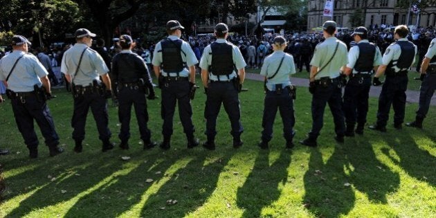 Police stand guard as people protest at Hyde Park in Sydney on September 15, 2012, as a wave of unrest against a film that mocks Islam spread to Australia, bringing hundreds out to demonstrate. Furious protests targeting symbols of US influence flared in cities across the Muslim world on September 14 in retaliation for a crude film made in the United States by a right-wing Christian group that ridicules the Prophet Mohammed. AFP PHOTO / Greg WOOD (Photo credit should read GREG WOOD/AFP/GettyImages)