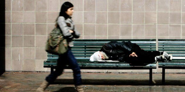 Ausralia, Sydney, homeless man sleeping on a bench, passer-by