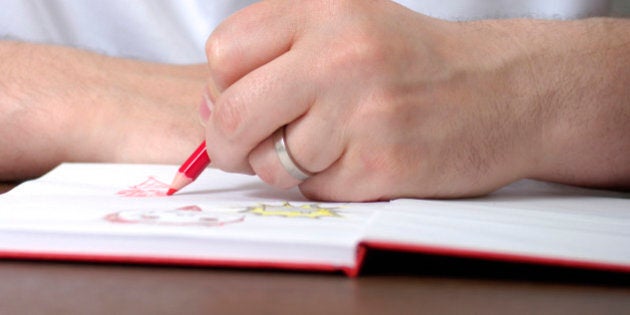 man drawing in book