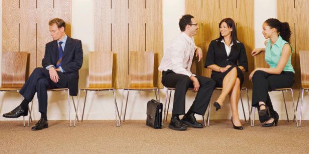 Business people ignoring businessman in waiting area