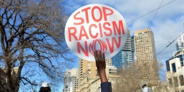 MELBOURNE, AUSTRALIA - JULY 18: An anti-racism activist holds up a placard as anti-Islam protesters stage rally in Melbourne, Australia on July 18, 2015. Hundreds of police were deployed in Western Australia on Saturday to break up violent protests near Parliament House in Melbourne after demonstrators from a right wing anti-Islam group faced off against anti-racism groups. (Photo by Recep Sakar/Anadolu Agency/Getty Images)