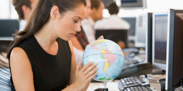 Businesswoman in office space with desk globe
