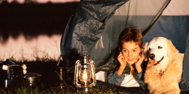 Boy lying in a tent with his dog