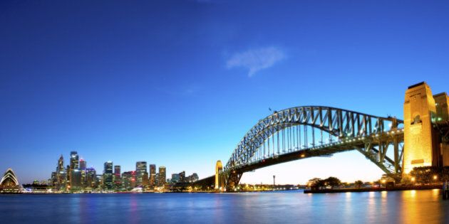 Panorama of Sydney Harbour with the opera house to the left, Financial district in the middle, and the harbour bridge to the right.