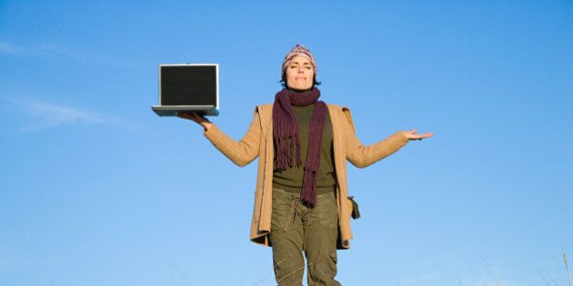 Serene woman in field with laptop