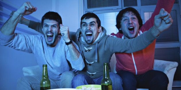 Three young men excited by goal scored during sports competition