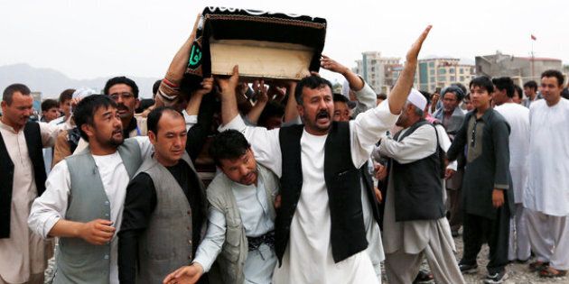 Men carry the coffin of a victim a day after a suicide attack in Kabul, Afghanistan July 24, 2016. REUTERS/Mohammad Ismail